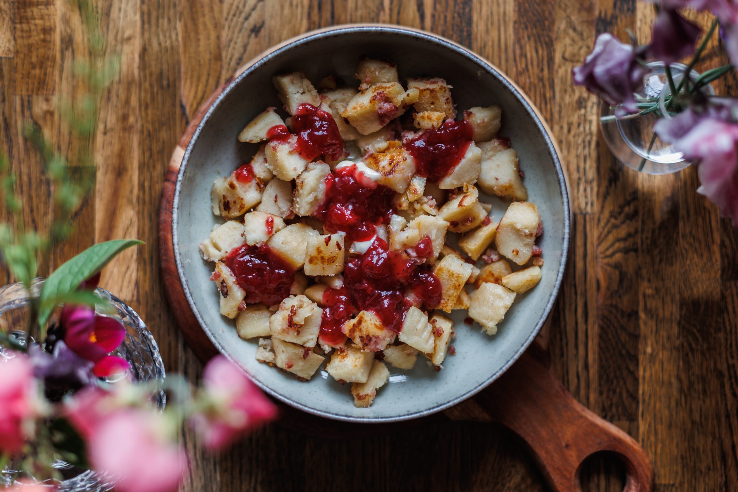 Ugnspannkaka skuren i bitar med lingonsylt i en skål